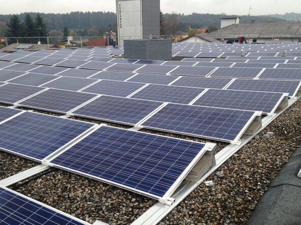 Photovoltaikmodule auf einem Flachdach mit Bergpanorama