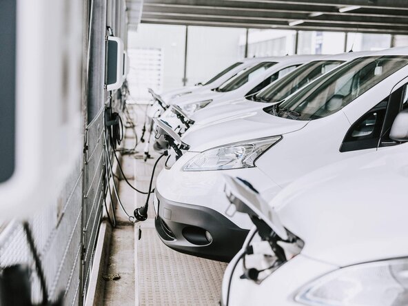 Mehrere weiße Firmenfahrzeuge sind an Wallbox angeschlossen