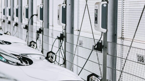 Mehrere weiße Firmenfahrzeuge sind an Wallbox angeschlossen
