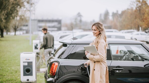 Mitarbeiterin lädt ihr Auto an einer Mitarbeiterladestation