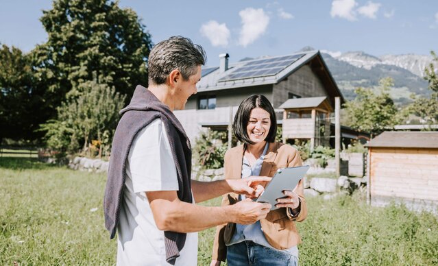 Mann zeigt Frau die eingespeiste Strommenge auf dem Tablet