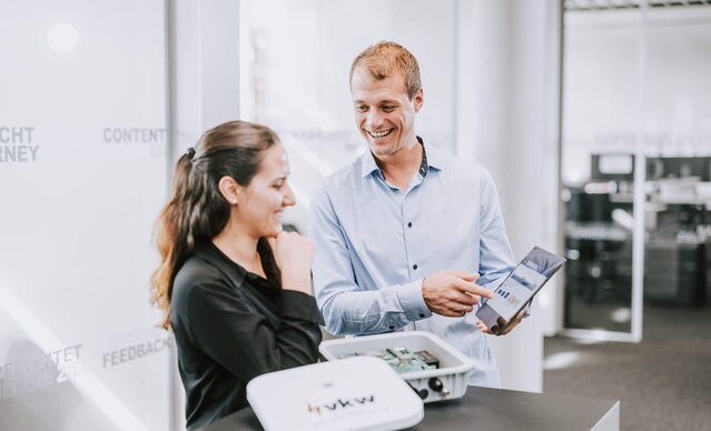 Mann zeigt Frau etwas auf dem Tablet