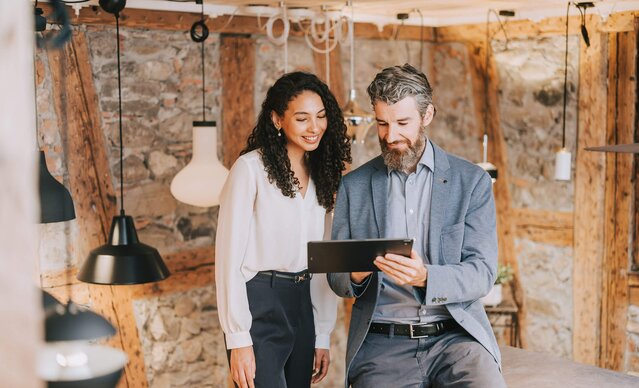 Mann zeigt Frau etwas auf dem Tablet in einem Lampengeschäft