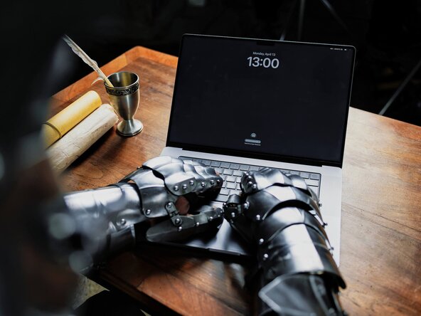 Ritter tippt mit seiner Rüstung auf dem Laptop