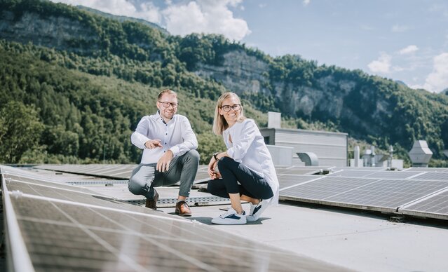 Ein Mann zeigt einer Frau die PV Anlage auf dem Dach