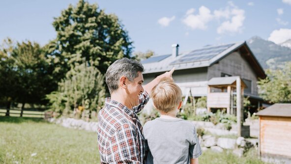 Vater zeigt seinem Sohn die PV Anlage auf dem Dach