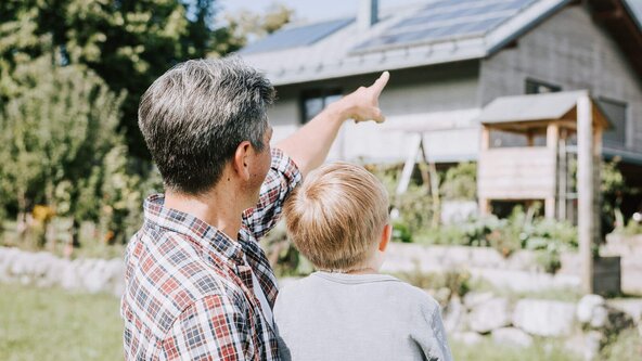 Vater zeigt seinem Sohn die PV Anlage auf dem Dach