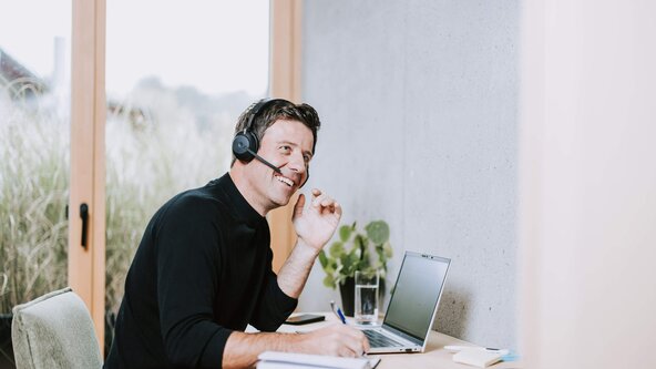 Mann telefoniert mit Handy an Schreibtisch