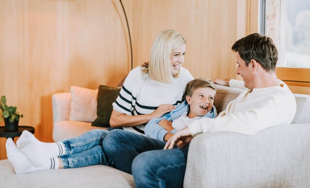Familie sitzt auf Couch in Wohnzimmer