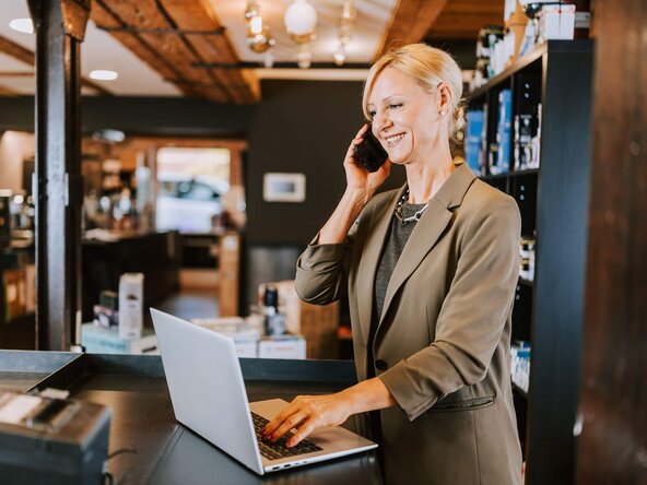 Ladenbesitzerin telefoniert in ihrem Geschäft
