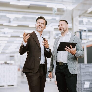 Kundenbetreuer führt Gespräch mit Unternehmer vor Serverschränke