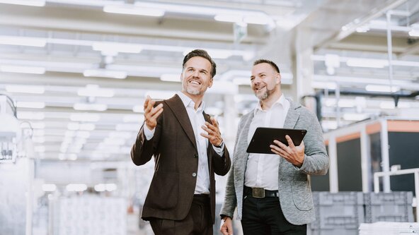 Kundenbetreuer führt Gespräch mit Unternehmer vor Serverschränke