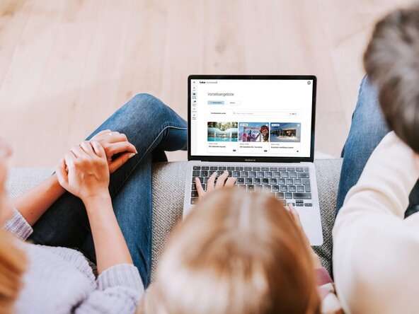 Familie sitzen auf Couchtisch sieht in Laptop
