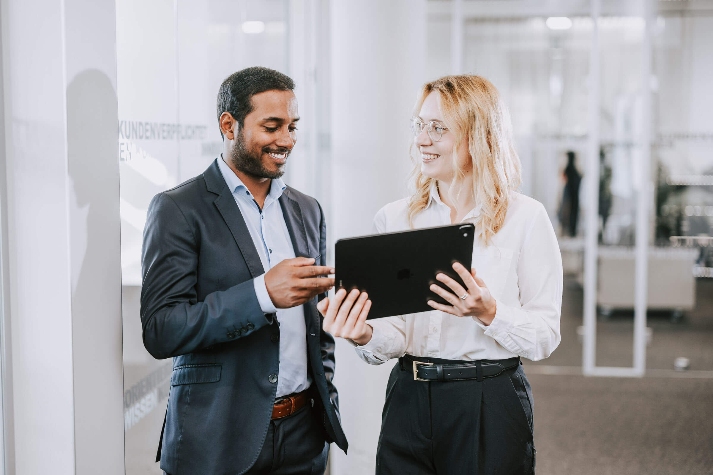 Mann und Frau im Büro sehen aufs Tablet