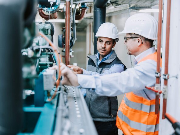 Ein Mann zeigt einem anderen die Heizung